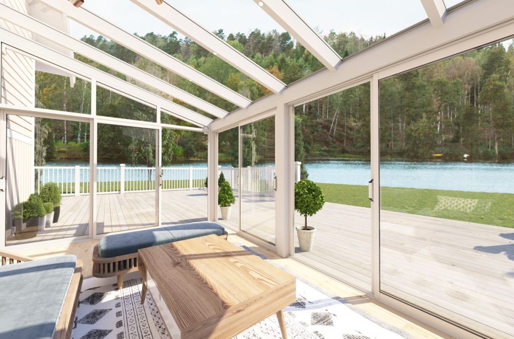 interiörbild av vitt uterum i aluminium exal nordic 140 vår & höst. utsikt mot trädgård med vatten i bakgrunden