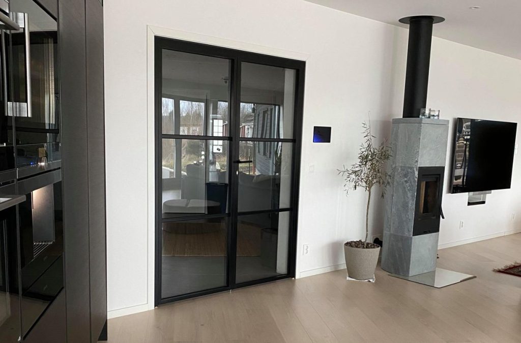 En stilfull och skräddarsydd dubbelslagdörr med industridesign. Svarta aluminiumprofiler matchar den moderna interiören